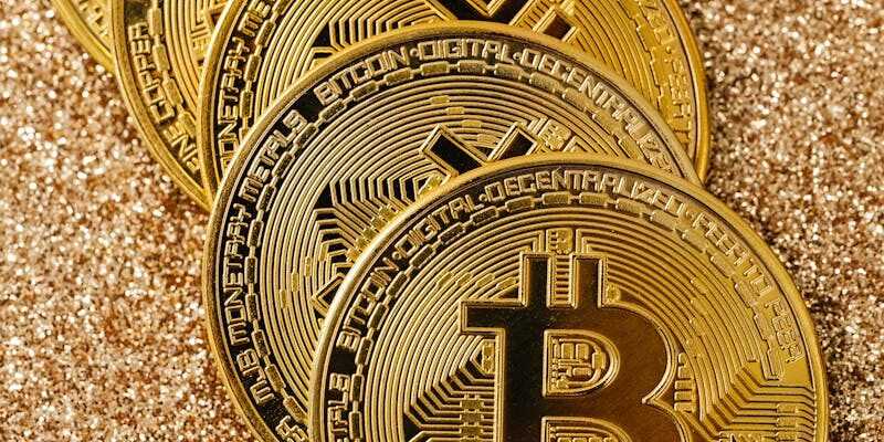 Golden Bitcoin cryptocurrency coins stacked on a glittering surface representing digital wealth and blockchain.