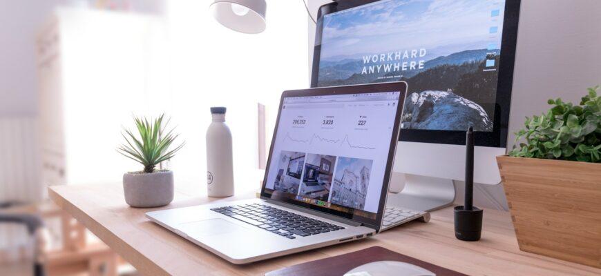 MacBook Pro on table beside white iMac and Magic Mouse