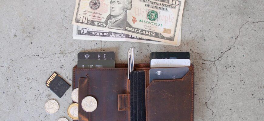 10 us dollar bill beside black leather wallet and coins